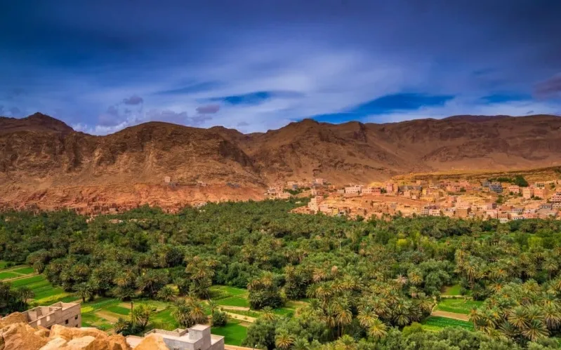 Scenic view of the Atad Valley in Morocco, featuring the stunning sand dunes of Erg Chebbi in the background.