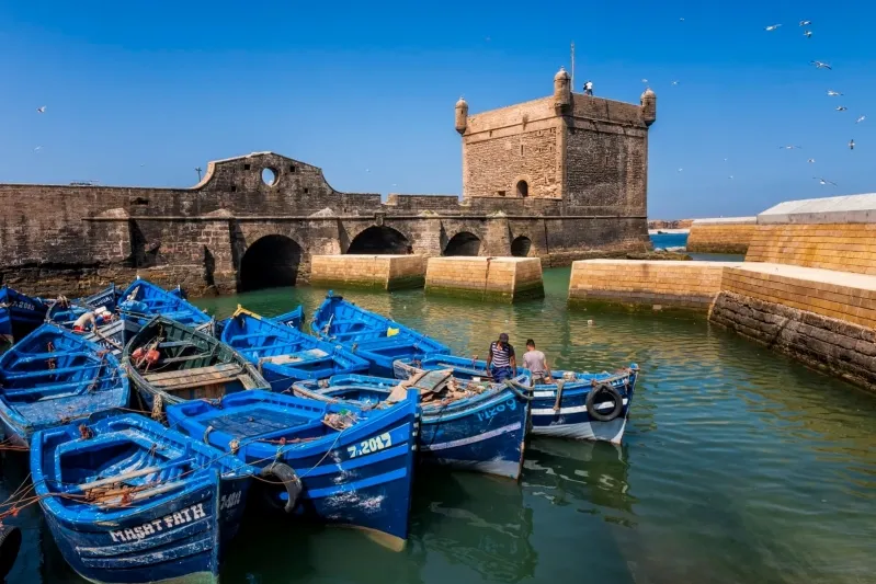 Un patio avec une table et des chaises sous un parasol, idéal pour se détendre lors d'un voyage organisé au Maroc.