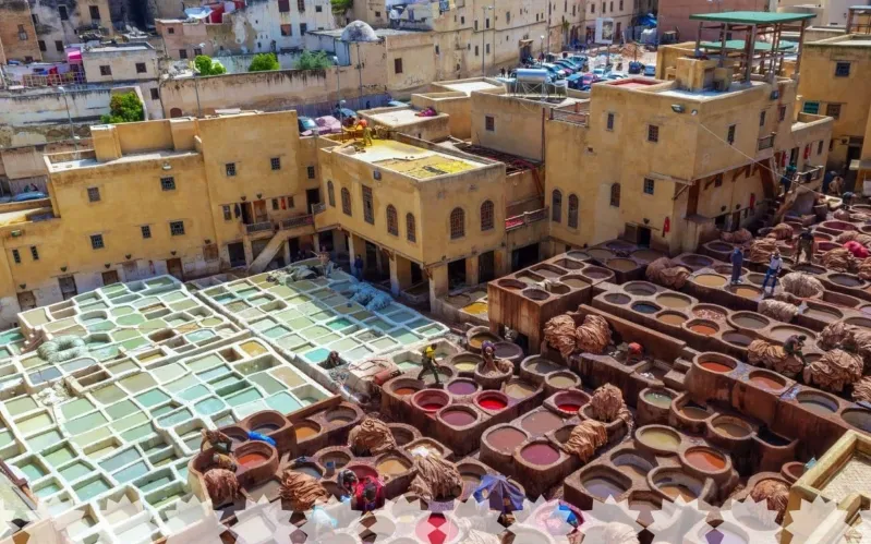 Crowds of people in a Moroccan city, each with pots, illustrating the lively atmosphere of maroc villes impériales .