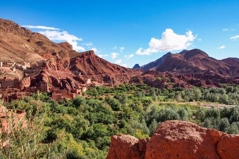 Red mountains rise majestically in the Desert de Marrakech, showcasing the unique landscape of Morocco's arid terrain.