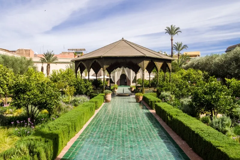 Jardin du palais royal à Marrakech, avec des plantes luxuriantes et des allées bien entretenues, représentant la beauté marocaine.