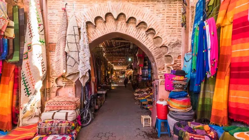 Marché animé à Marrakech, mettant en valeur l'artisanat marocain avec des étals colorés et des produits traditionnels.