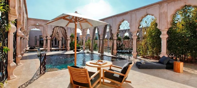  La piscine du riad Al-Marrakesh, entourée de palmiers et de mosaïques, à Dakhla au Maroc.