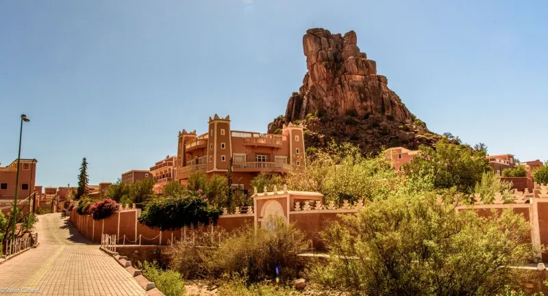 Vue d'un village désertique de Tafraout, Maroc, avec une montagne majestueuse en arrière-plan.