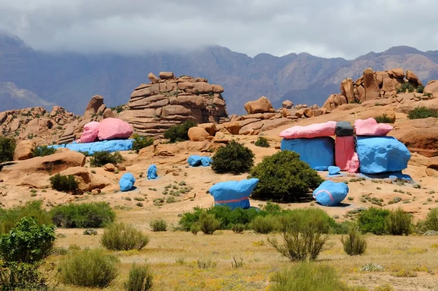 Un groupe de tentes colorées dans le désert de Tafraout, Maroc, sous un ciel bleu clair.